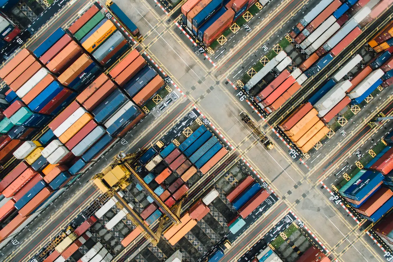 Aerial view of rows of stacked shipping containers in a port yard